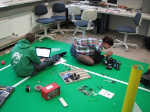 Bild von AG-Mitgliedern die am Roboter rumschrauben